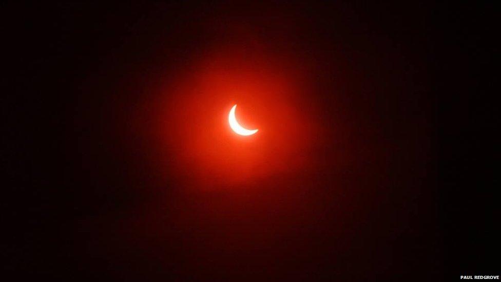 A glowing red image of Solar eclipse near totality over Altrincham, England