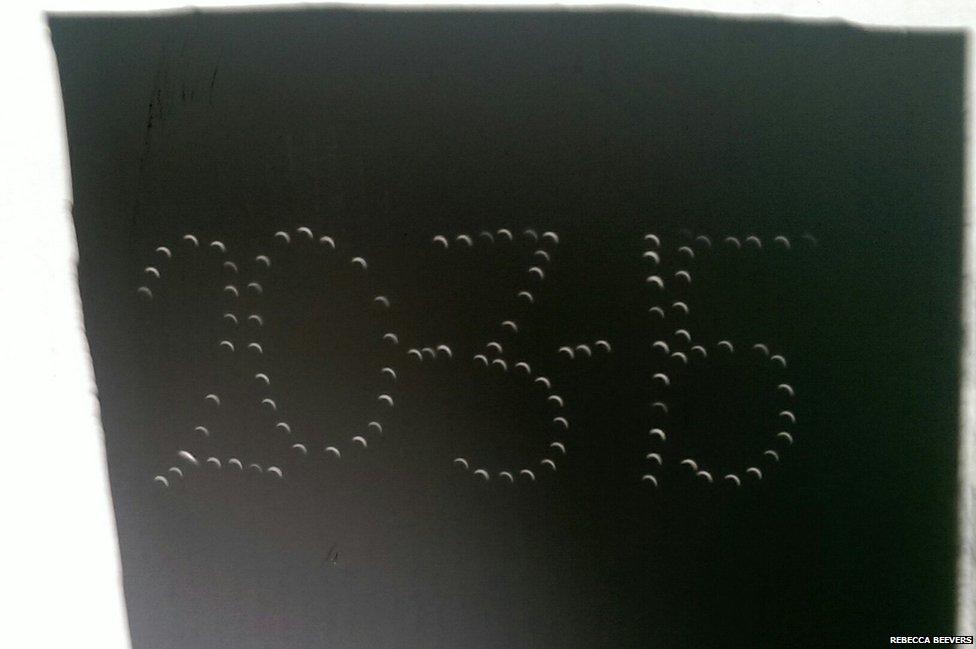 Pinhole shadow projection of the solar eclipse. The pinhole arrangement spells out the date, 20 March 2015