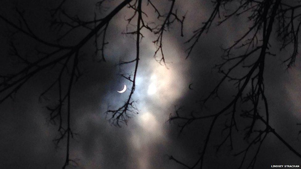 Solar eclipse pictured in a cloudy sky over Edinburgh, Scotland