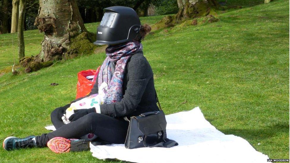 An eclipse watcher in the grounds of Glasgow University, taking eye protection precautions.