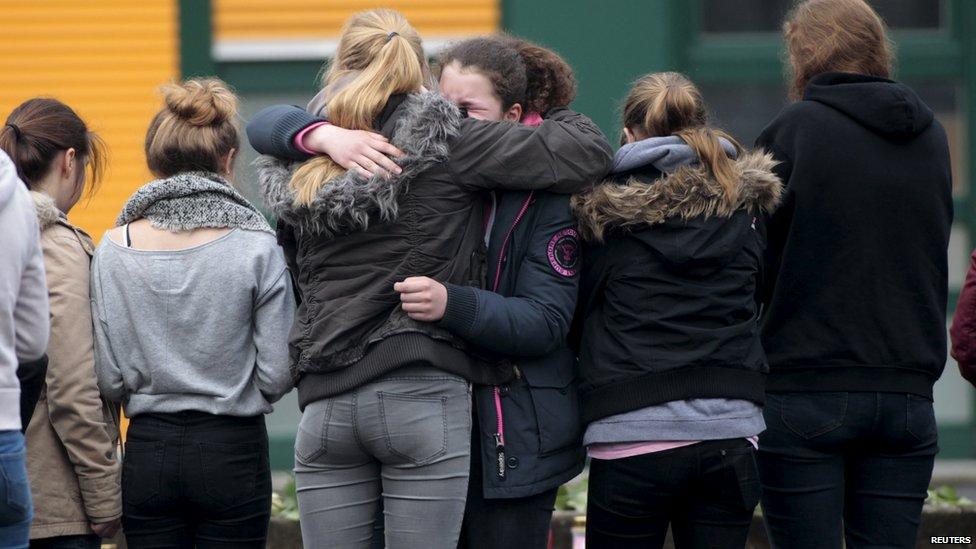 Students hug in front of the Joseph-Koenig-Gymnasium high school in Haltern am See