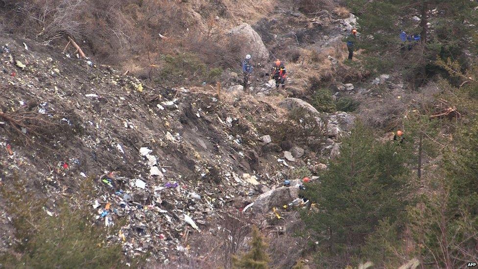 A screen grab taken from an AFP TV video on March 24, 2015 shows search and rescue personnel near scattered debris while making their way through the crash site of the Germanwings Airbus A320