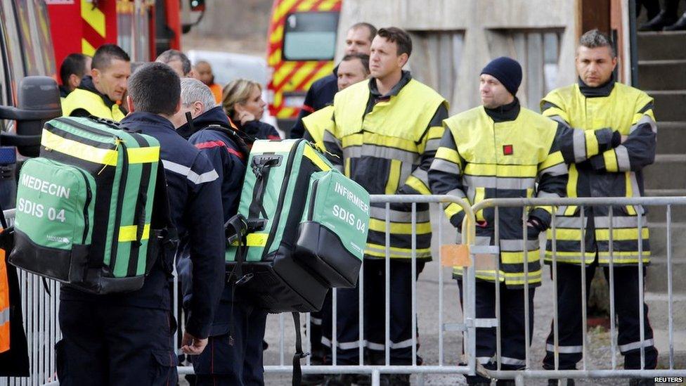 French firefighters gather outside the gymnasium where relatives and officials are due to pay tribute to the victims of the Airbus A320 crash in Seyne-les-Alpes