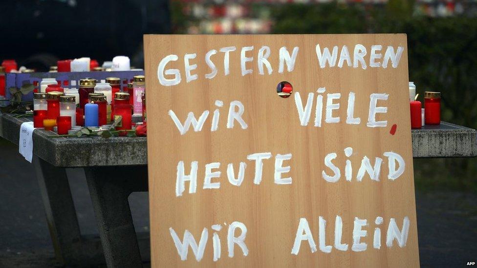 A poster reading "Yesterday we were many, today we are alone" can be seen in front of a memorial of flowers and candles near the Joseph-Koenig-Gymnasium secondary school in Haltern am See, western Germany