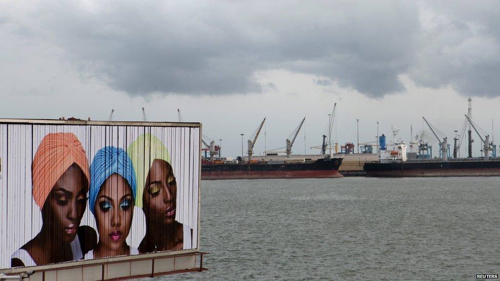 A sign for cosmetic products is seen in front of ships lined up at the Apapa port in Lagos, Nigeria, 11 April 2015