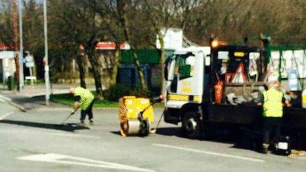 Workers dealing with the potholes in the road