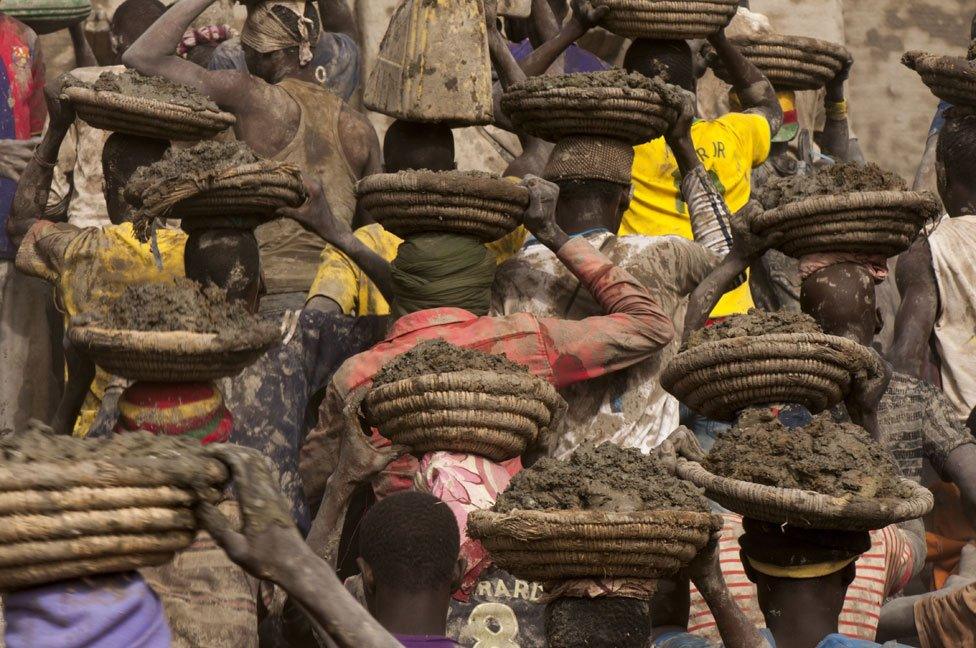 People carrying mud