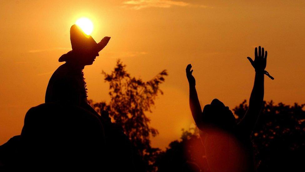 People in silhouette against the setting sun