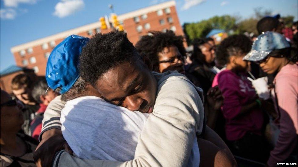 A man hugs a friend during prayers