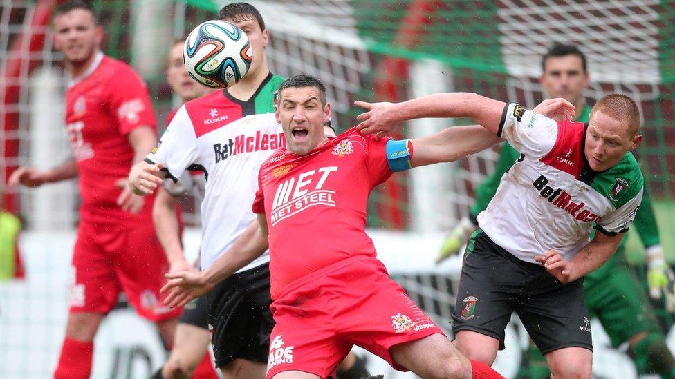 Portadown skipper Keith O'Hara goes down as Glentoran opponent Stephen McAlorum challenges