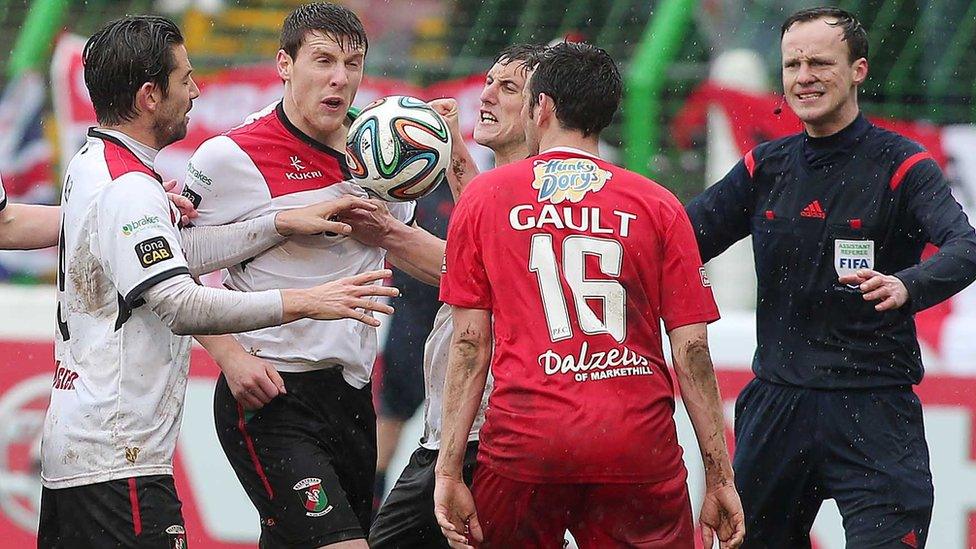 Glentoran and Portadown players are involved in heated exchanges during the big match at the Oval