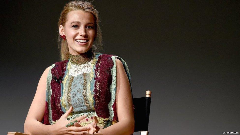 Blake Lively smiling, sitting in a chair ahead of an event in New York