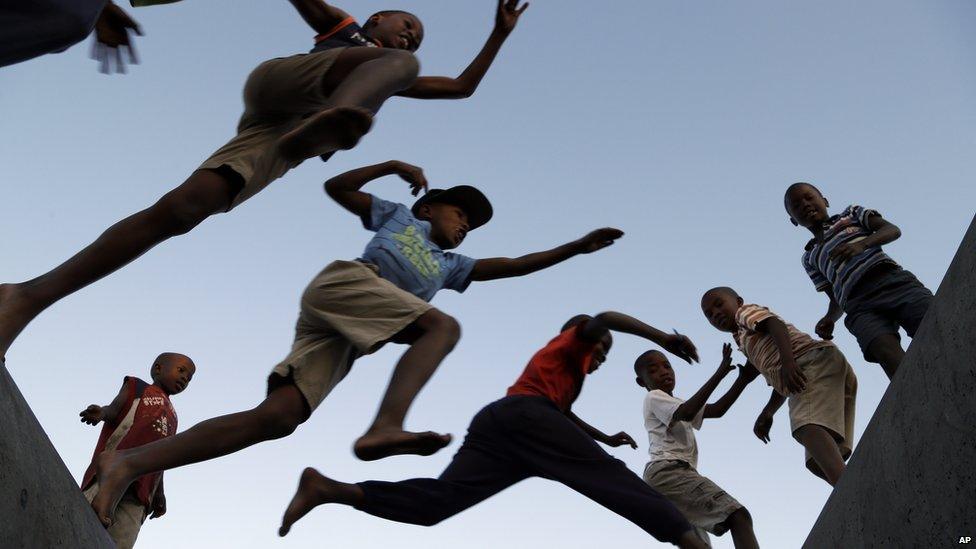 Young boys jumps from one concrete drainage pipe to another in a park in Katlehong, south of Johannesburg, South Africa, Wednesday, 6 May 2015