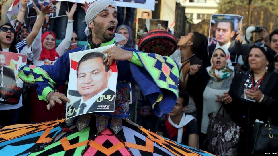 A dancer and supporter of ousted Egyptian president Hosni Mubarak performs a traditional Sufi (Al-Tannoura) Egyptian folk dance with his picture outside the area where he is hospitalized during his birthday in front of Maadi military hospital on the outskirts of Cairo 4 May 2015