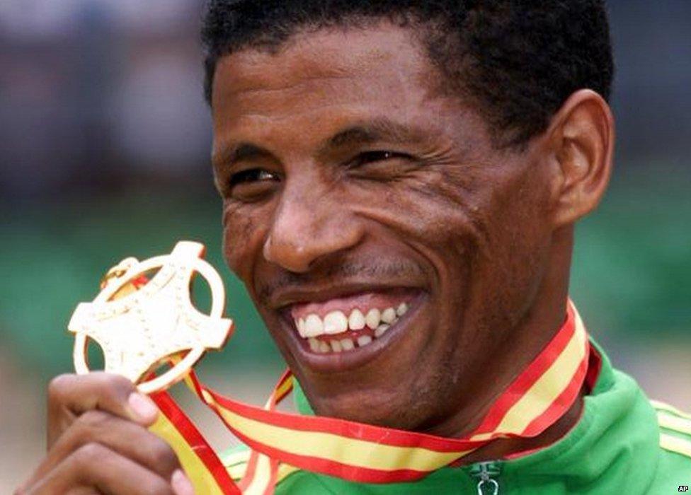 Haile Gebrselassie of Ethiopia displays his 10000-meter gold medal, following the presentation ceremony at the seventh World Track and Field Championships in Seville, Spain, Wednesday Aug. 25, 1999.(