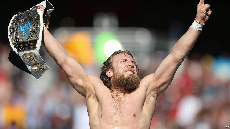 Daniel Bryan holding a belt in the air