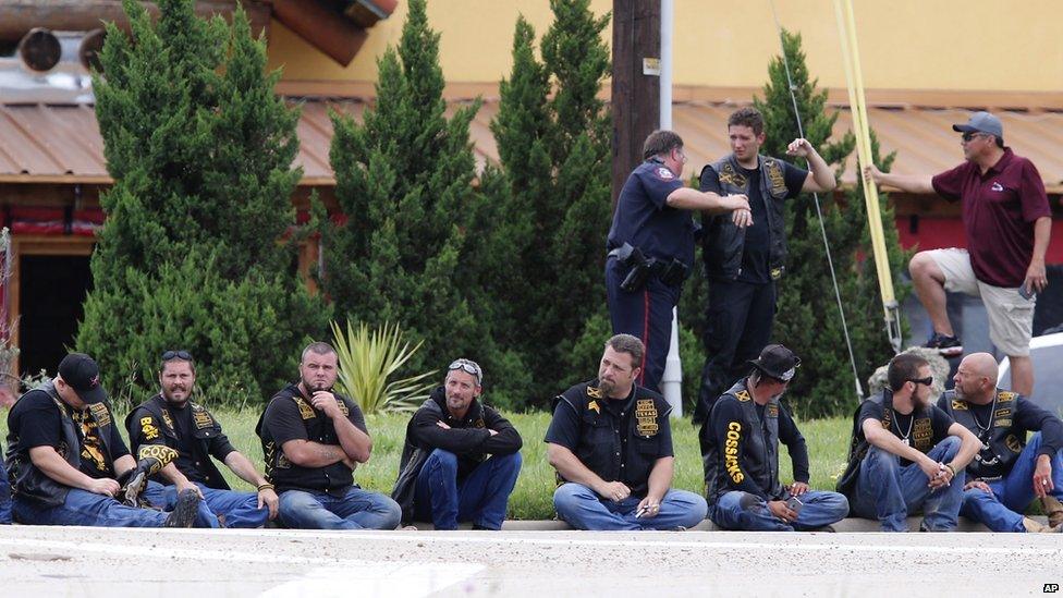 Gang members sitting on the street after the shootout