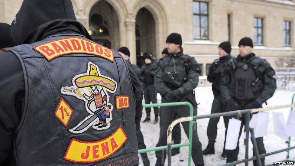 A man stands with his back to camera, showing the Bandido logo on his jacked