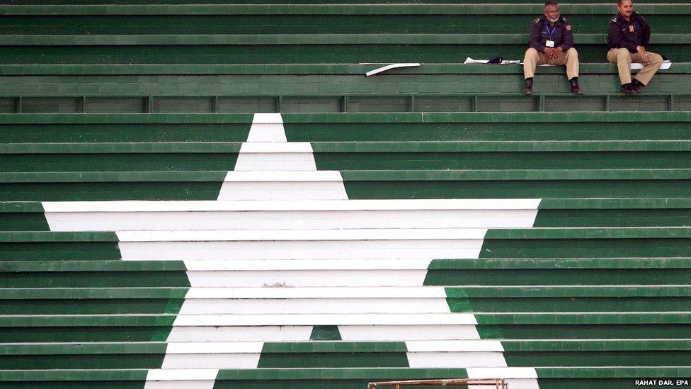 Two policemen watch a training session of Zimbabwe's Cricket team in Lahore (20 May 2015)