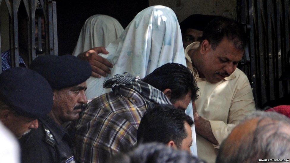 Members of the Pakistani security services escort suspects in a bus attack arrested during an operation in Karachi (21 May 2015)