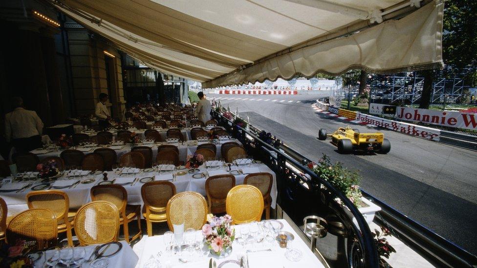 Ayrton Senna drives the 12 Camel Team Lotus Honda Lotus 99T past waiters and tables of a restaurant overlooking the circuit during practice for the Grand Prix of Monaco on 30 May 1987 on the streets of the Principality of Monaco in Monte Carlo