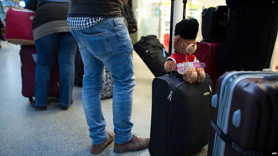 People queuing with luggage