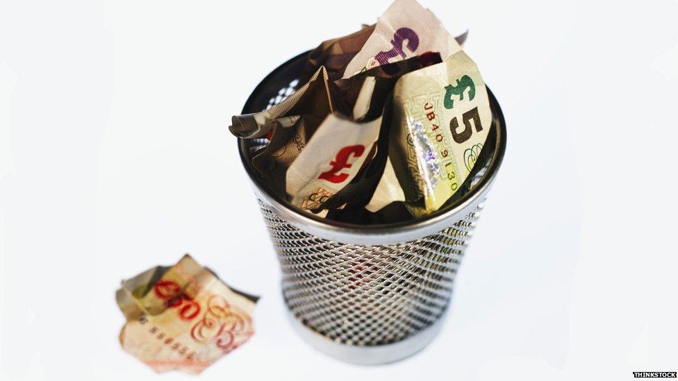 Wastepaper bin filled with money