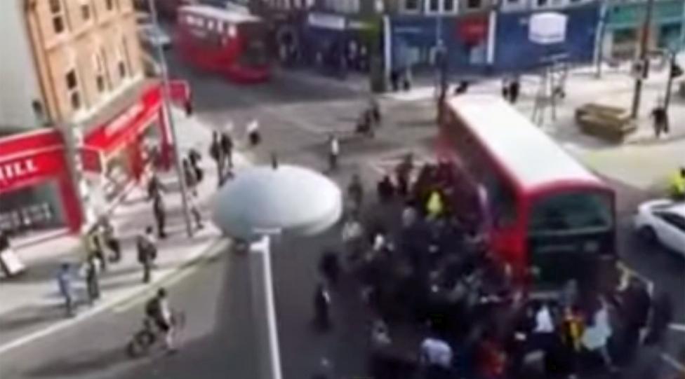 Blurry video grab of crowd around bus in Walthamstow - taken from above