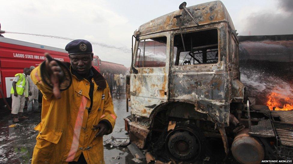 A fireman ushers the photographer out of the way