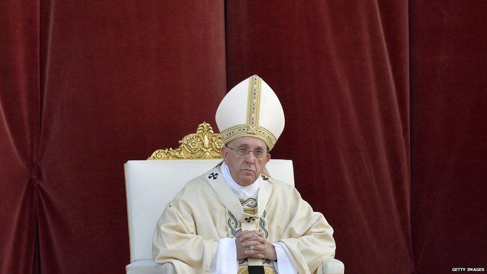 Pope Francis in front of red curtain