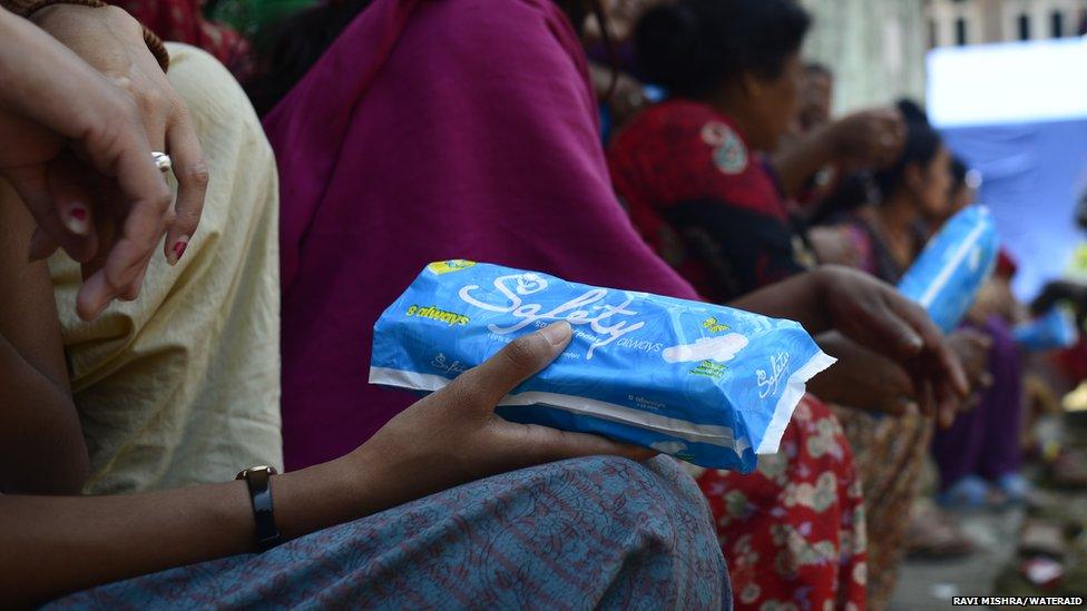 Woman holding a packet of sanitary towels