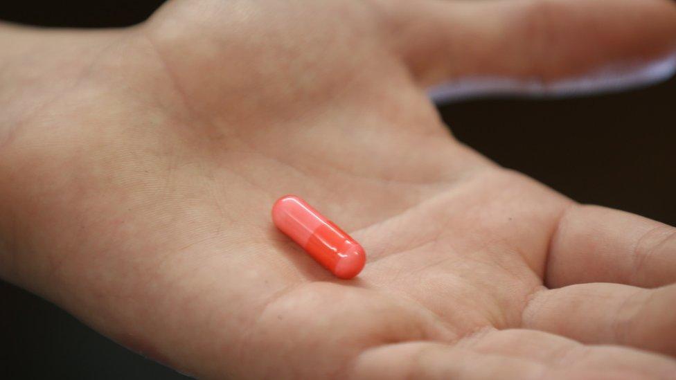 Hand holding a "legal high" pill