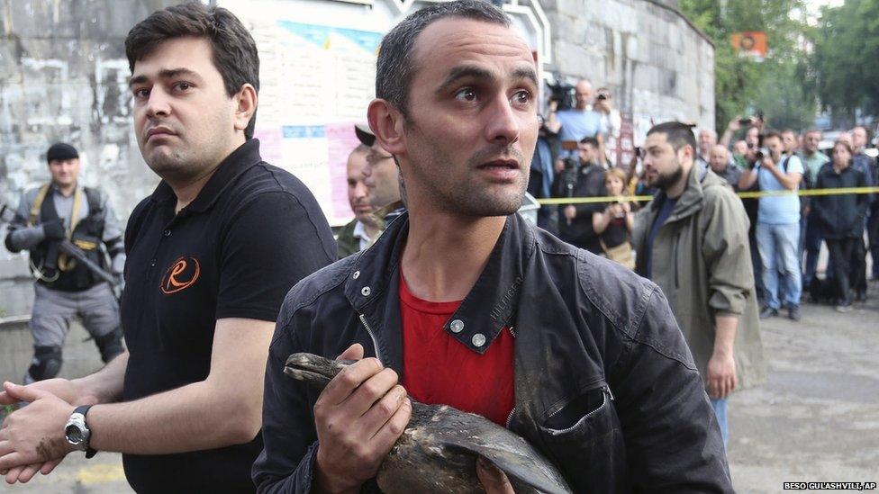 A man tries to save a bird from the flooded zoo in Tbilisi (14 June 2015)