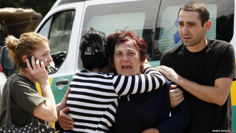 People comfort each other at a flooded area in Tbilisi, Georgia (14 June 2015)