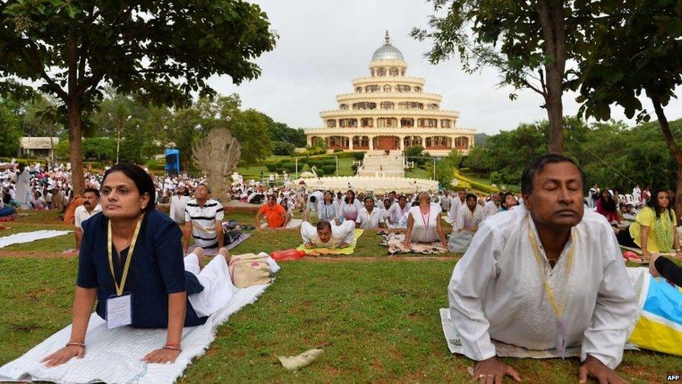 Participants of "The Sun Never Sets on Yoga" practice yoga at The Art of Living in Bangalore on June 13, 2015.