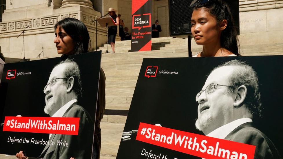 People listen as writers gather to read selected works of British author Salman Rushdie, one week after he was stabbed while on stage, during a rally to show solidarity for free expression outside the New York Public Library in New York City on August 19, 2022. 