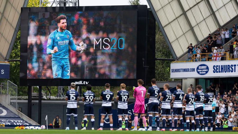 Milwall's players join in a minute's applause for their late former goalkeeper Matija Sarkic before their Championship match against Watford at The Den