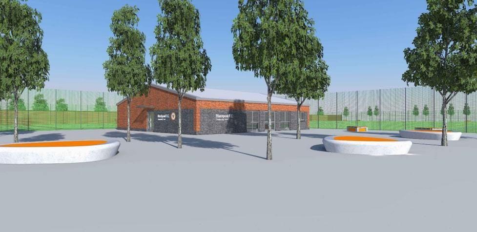 Artist impression of Revoe Sports Village- Grass pitches at the back and a red brick building with Blackpool FC written on the side, grey concrete in the foreground. 