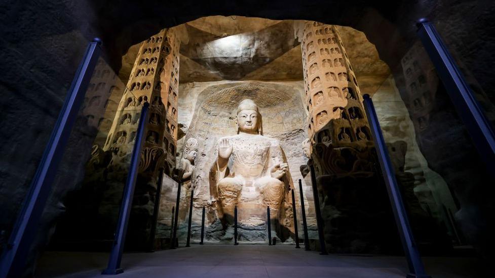 a buddha carved into rock at the yungang buddhist grottoes