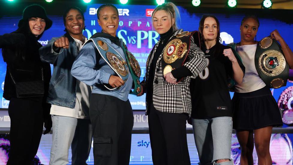 Karriss Artingstall, Cindy Ngamba, Natasha Jonas, Lauren Price, Raven Chapman and Caroline Dubois all pose for pictures together at a news conference