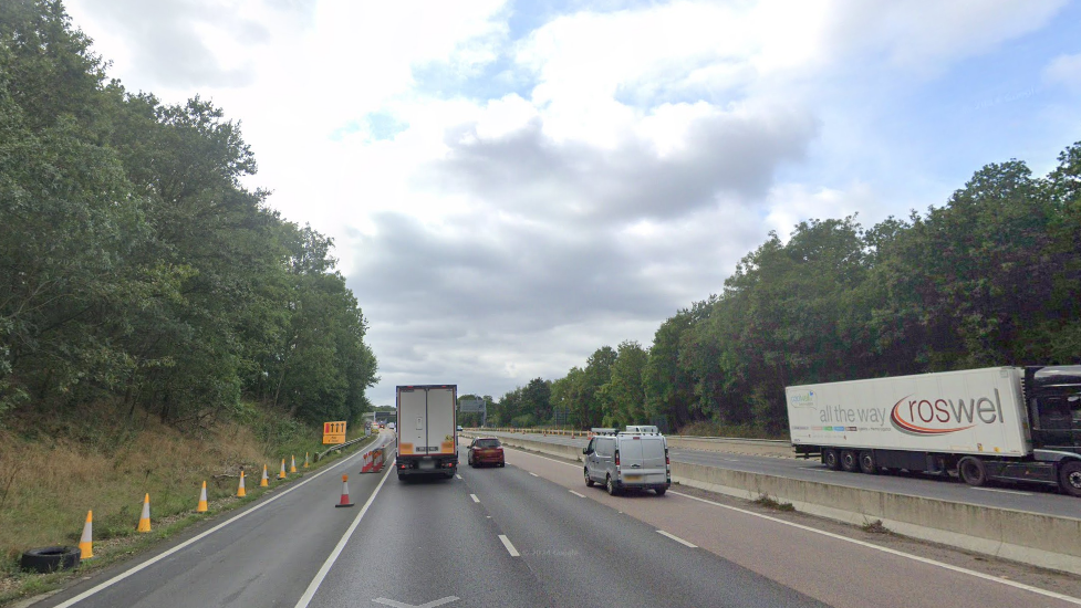 A Google map street view of the M20 London-bound carriageway between 2 and 3. There are two lorries, a van and a car on the road, with green trees either side.