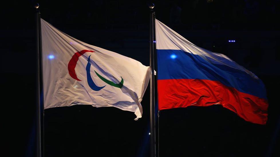 Paralympic flag and Russia flag flying side-by-side