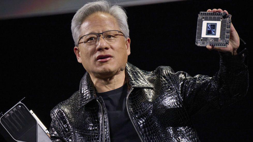 Jensen Huang, co-founder and chief executive officer of Nvidia, speaks while holding the company's new GeForce RTX 50 series graphics cards and a Thor Blackwell robotics processor during the 2025 CES event in Las Vegas, Nevada, US.