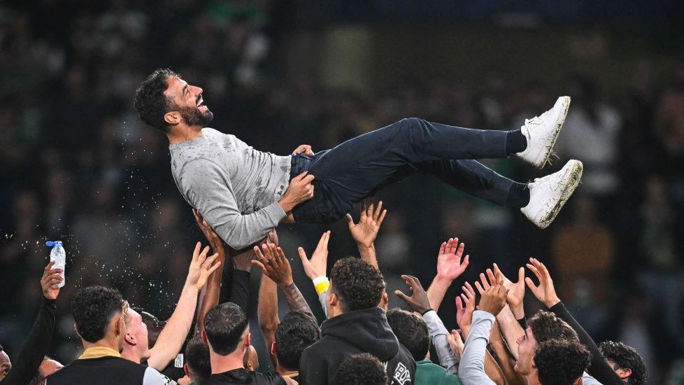 Ruben Amorim is lifted up into the air by his celebrating Sporting players