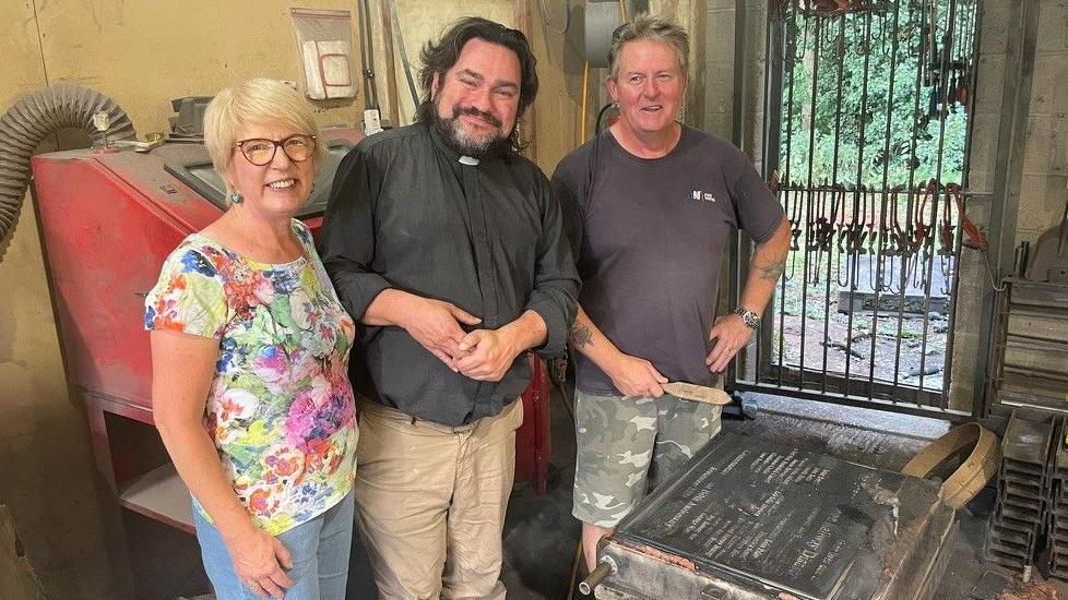 Phyllida Scrivens, Rev James Stewart, the rector of Thorpe St Andrew, and plaque maker Gary Hubbard with the memorial to be placed in the church