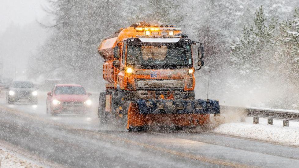 Cars follow gritter vehicle as it clears snow and ice in Inverness