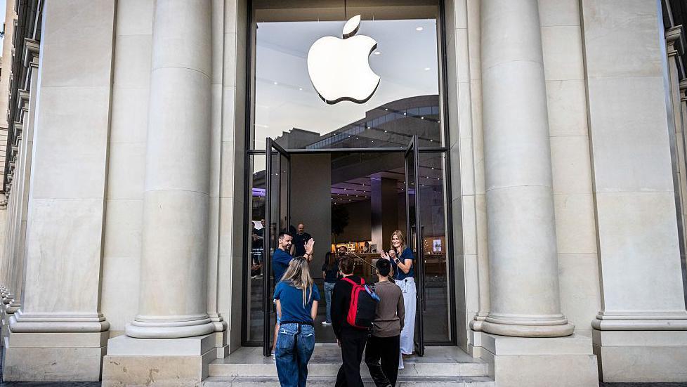 Customers standing in front of an Apple Store in Barcelona, Spain.