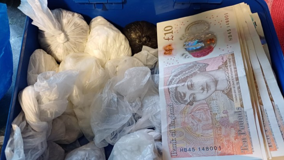 A police-issued photograph showing white power in tied-up plastic bags and a pile of £10 notes.