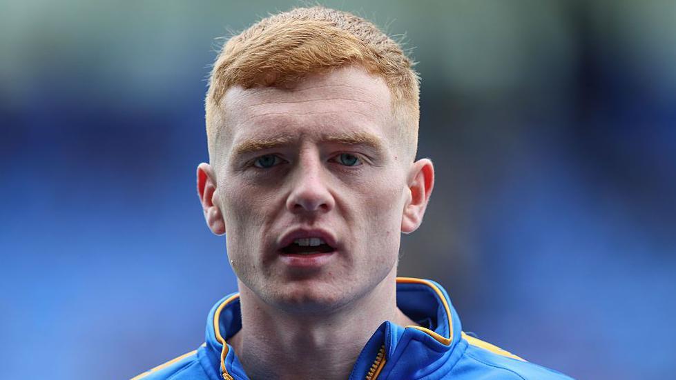 Carlisle captain Morgan Feeney looking straight ahead, wearing a tracksuit
