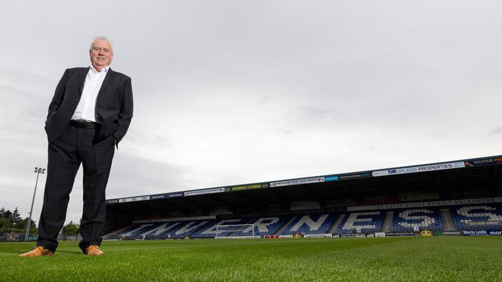 Alan Savage standing on the pitch with stadium in background